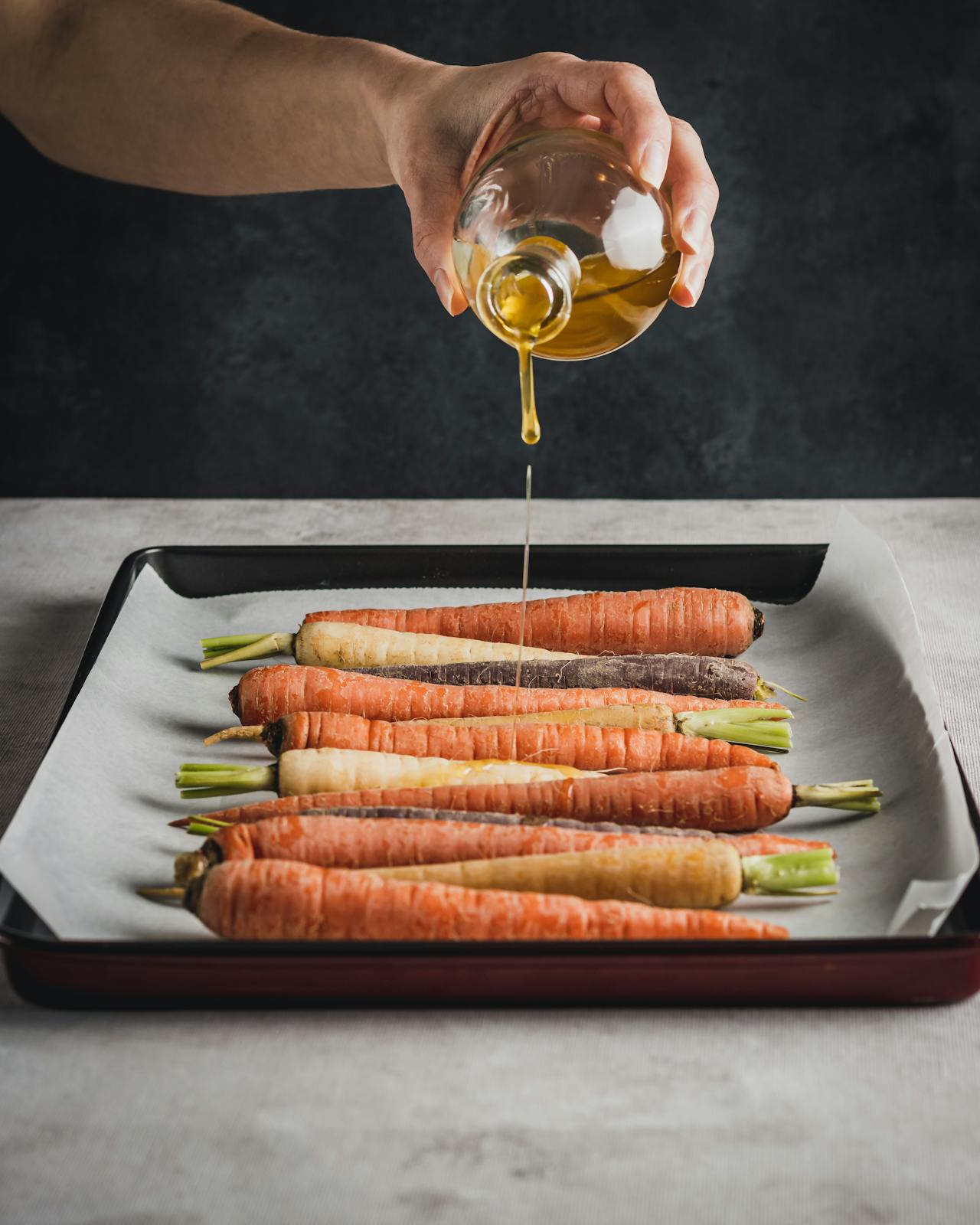 pouring oil over carrots